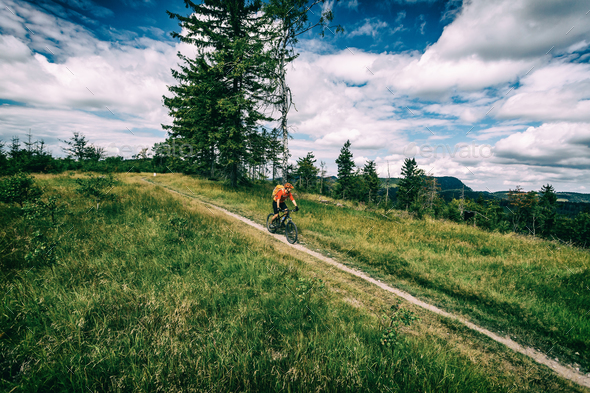 Mountain biking man riding in woods and mountains Stock Photo by blas