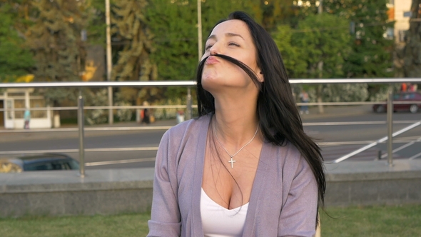 Young Woman Is Playing with Her Hair Portraying a Mustache