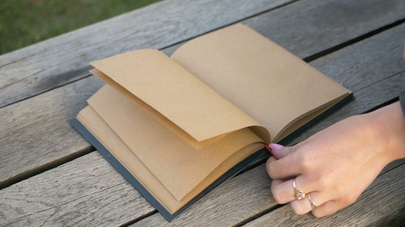 Woman's Hand Slowly Turns the Pages of a Clean Book with a Bookmark