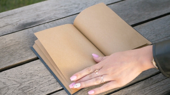 Woman's Hand Slowly Turns the Page of a Clean Book