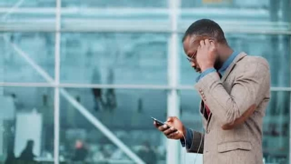African American Businessman Listens to the Music and Dances while He Walks near the Office Building alt