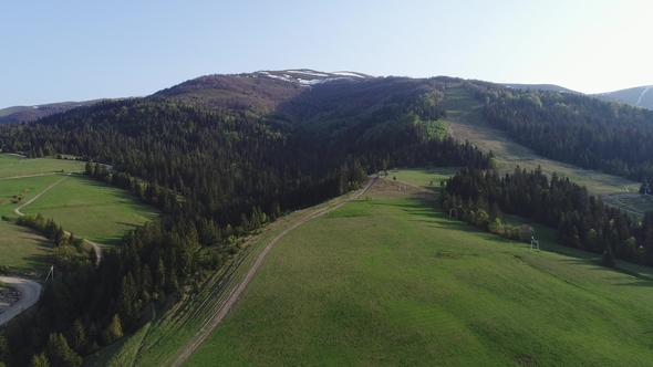 Flight Over the Forest in the Mountains and Village . Aerial View of Ukrainian Carpathians