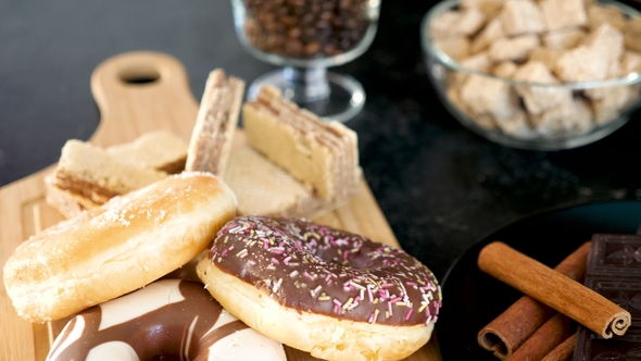 Donuts on a Wooden Board and Dark Chocolate in a Plate alt