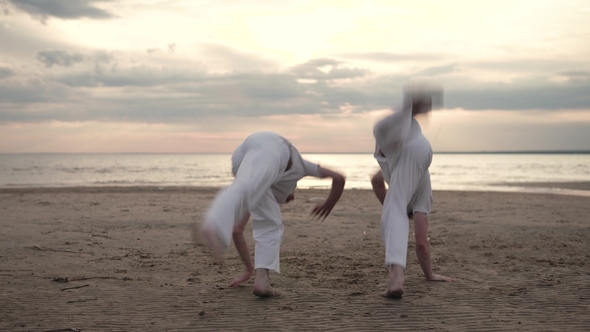 Two Men Practicing Capoeira on Beach alt