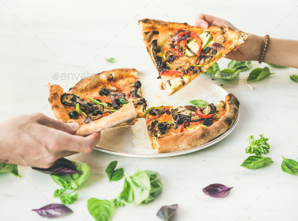 People's hands taking pieces of Freshly baked vegetarian pizza - Stock Photo - Images