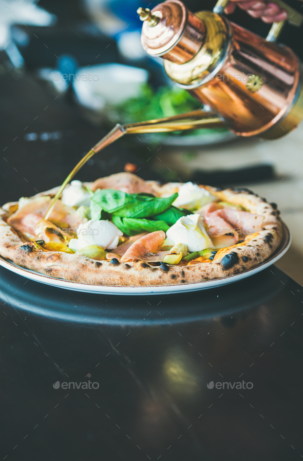 Freshly baked Italian pizza with ham, artichokes served in restaurant - Stock Photo - Images