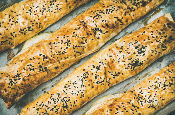Freshly baked Turkish borek pastry rolls with spinach, top view - Stock Photo - Images