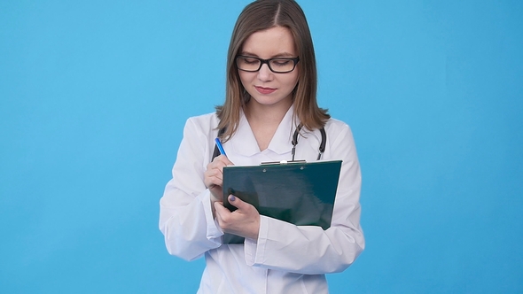 Young Female Doctor in White Coat with Clipboard alt