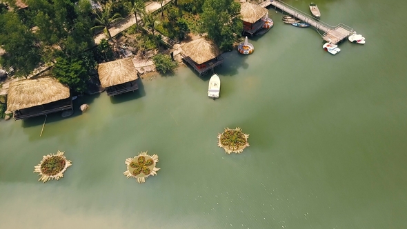 Summer Bungalows with Thatched Roof and Boat Pier on Shore Green Lake in Luxury Mountain Hotel alt