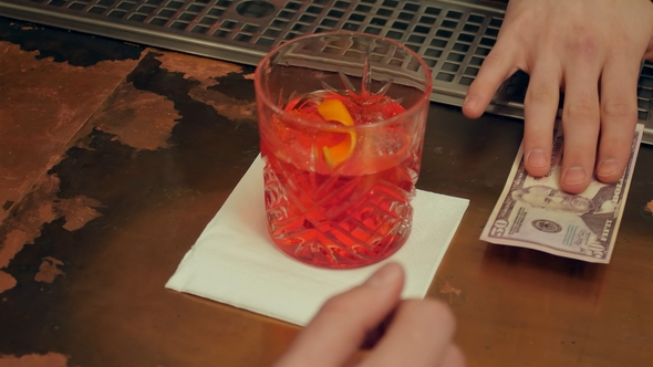 Bartender's Hand Is Giving Out the Prepared Cocktail and Visitor Hand Pay By Cash alt
