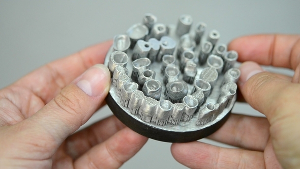 Man Is Holding Object Printed on Metal 3d Printer. alt