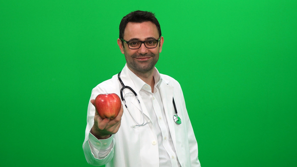 Doctor Holding an Apple Against a Green Screen