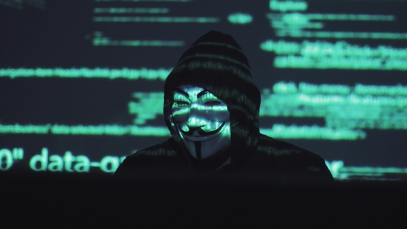A Male Robber in a Mask Works on a Computer in a Dark Room. Computer ...