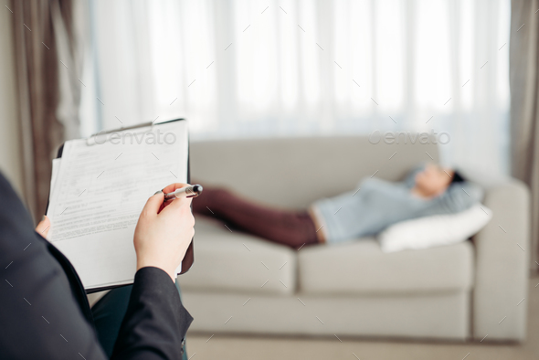 Patient lies on sofa at psychotherapist reception - Stock Photo - Images