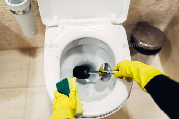 Housemaid in gloves cleans the toilet with brush - Stock Photo - Images