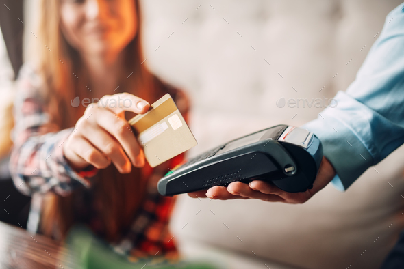 Young woman paying with credit card in cafe Stock Photo by NomadSoul1