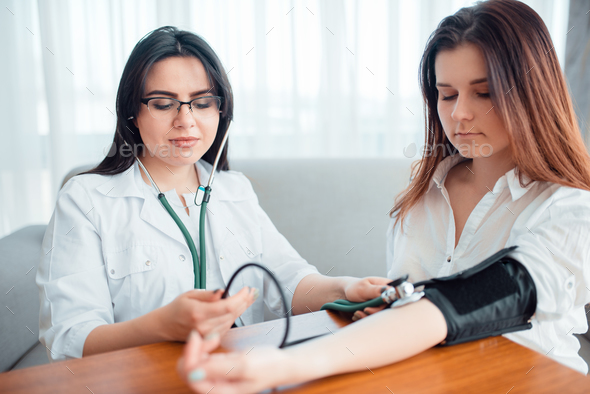 Doctor measures body pressure of a young mother - Stock Photo - Images