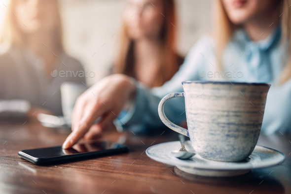 Cup of coffee and phone on wooden table, closeup - Stock Photo - Images