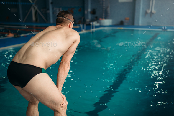 Swimmer in goggles prepares to jump, back view Stock Photo by NomadSoul1