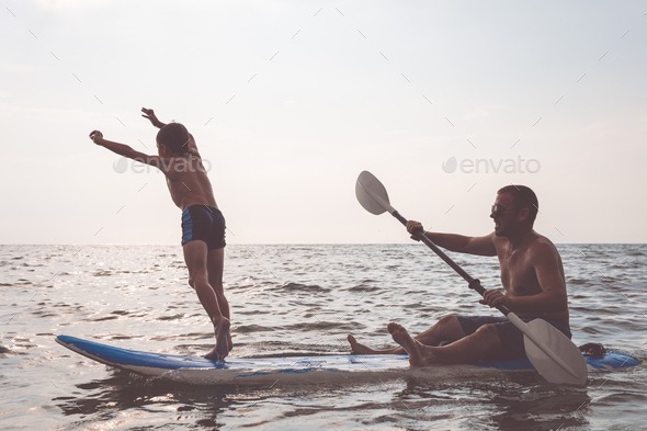 Father and son playing on the beach at the day time. - Stock Photo - Images