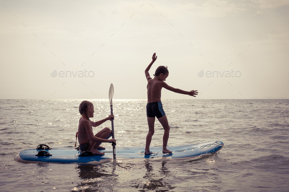 Happy children playing on the beach at the day time. - Stock Photo - Images