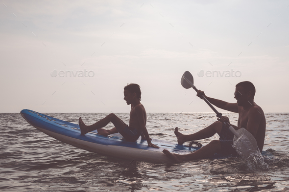 Father and son playing football on the beach at the day time. - Stock Photo - Images