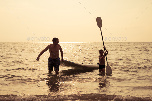 Father and son  playing on the beach at the day time. - Stock Photo - Images