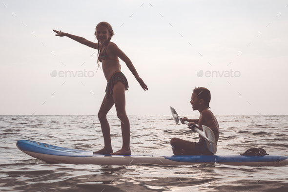 Happy children playing on the beach at the day time. - Stock Photo - Images