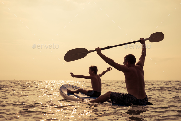 Father and son playing on the beach at the day time. - Stock Photo - Images