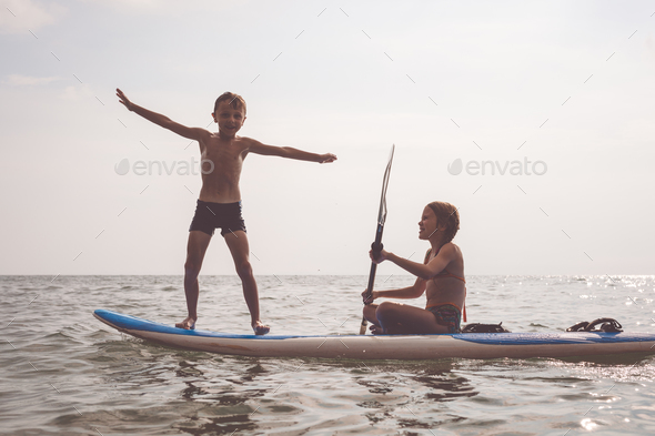 Happy children playing on the beach at the day time. - Stock Photo - Images