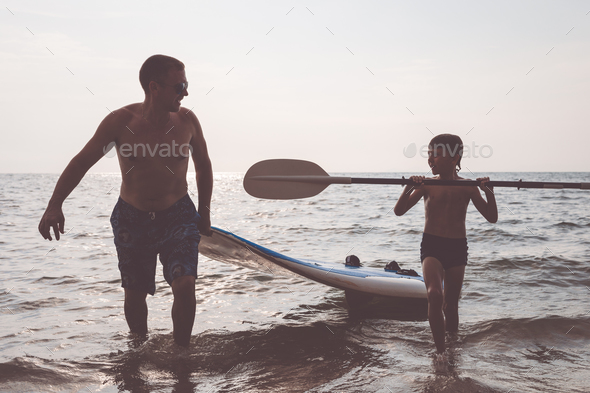 Father and son playing on the beach at the day time. - Stock Photo - Images