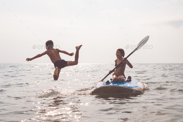 Happy children playing on the beach at the day time. - Stock Photo - Images