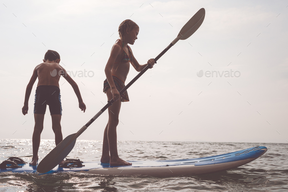 Happy children playing on the beach at the day time. - Stock Photo - Images