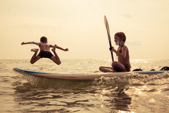 Happy children playing on the beach at the day time. - Stock Photo - Images