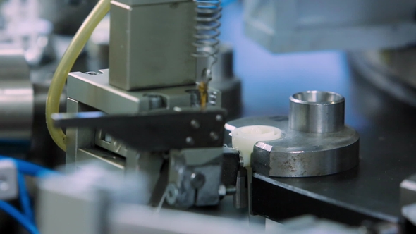 The Machine Inserts the Lid on the Production of Droppers at the Medical Equipment Factory alt