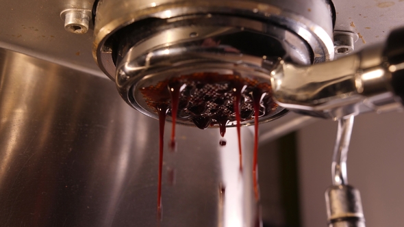 Bottomless Filter of Coffee Machine and Hot Coffee Pouring Through It.   Shot alt