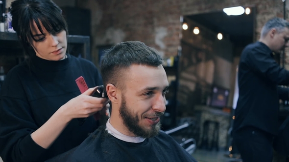 Hairdresser Girl Shears the Guy with a Clipper