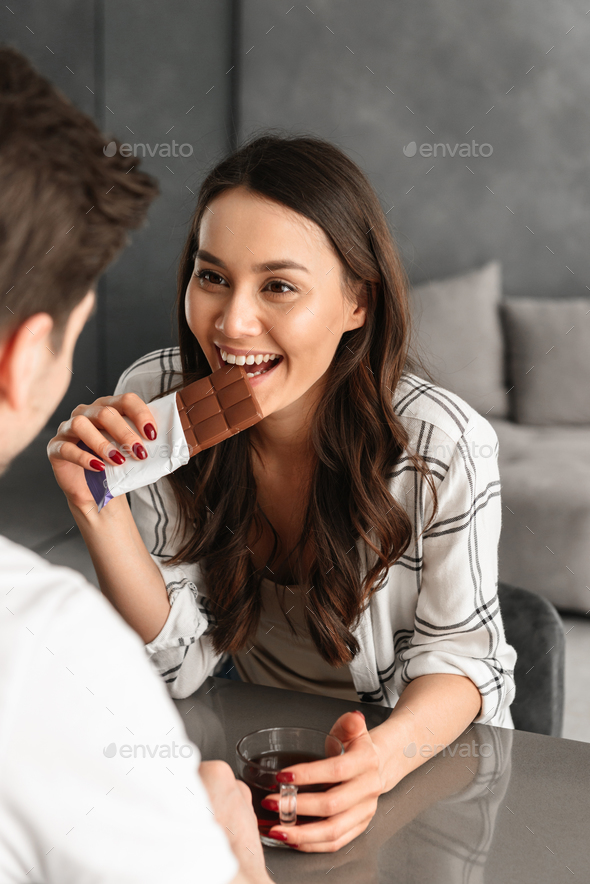 Photo of lovely smiling woman looking at man, while sitting toge - Stock Photo - Images