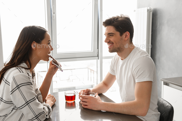 Image of attractive man and woman looking at each other, while s - Stock Photo - Images