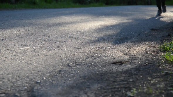 Sport Man Running at Asphalt Road. Rural City Park. Green Tree Forest and Sun Rays on Horizon.