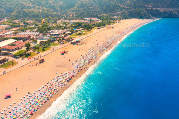 Aerial view of sandy beach with colorful chaise-lounges and blue sea - Stock Photo - Images