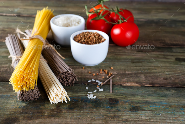 bunch of Italian spaghetti, noodles soba and sommel, bowls with buckwheat and rice with tomato - Stock Photo - Images