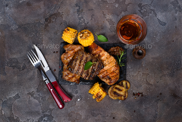 Fresh three types of grilled steak on slate plate with herbs, juice and grilled potatoes - Stock Photo - Images