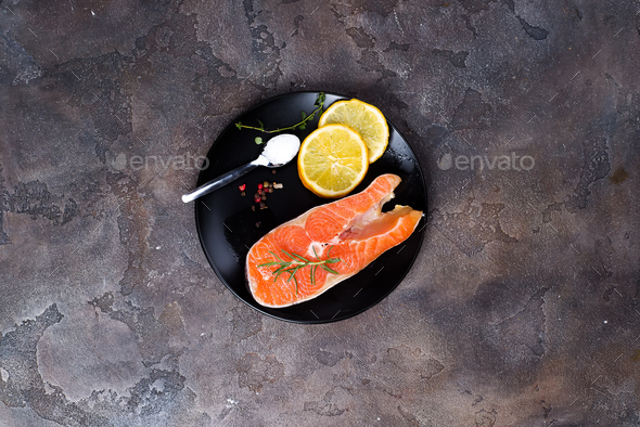 Salmon steaks on ice withlemon slice on wooden plate - Stock Photo - Images