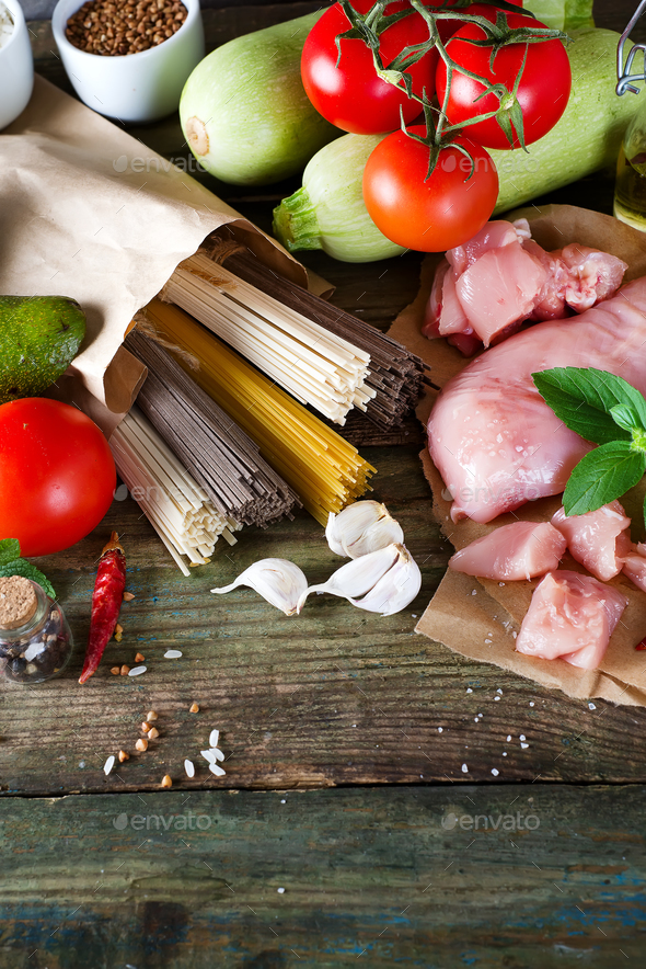 bunch of Italian spaghetti, noodles soba and sommel, chicken raw meat, avocado, zucchini with tomato - Stock Photo - Images