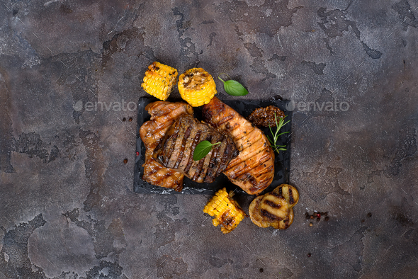 Fresh three types of grilled steak on slate plate with herbs and grilled potatoes - Stock Photo - Images
