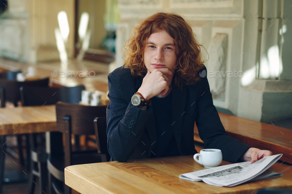 Young man thinking while having coffee - Stock Photo - Images