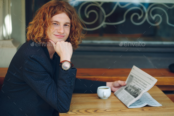 Hipster man drinking coffee while reading - Stock Photo - Images