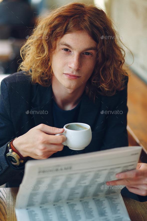 Hipster man drinking coffee while reading - Stock Photo - Images