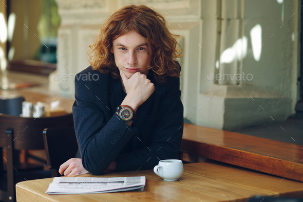 Young reddish man posing touching his chin - Stock Photo - Images